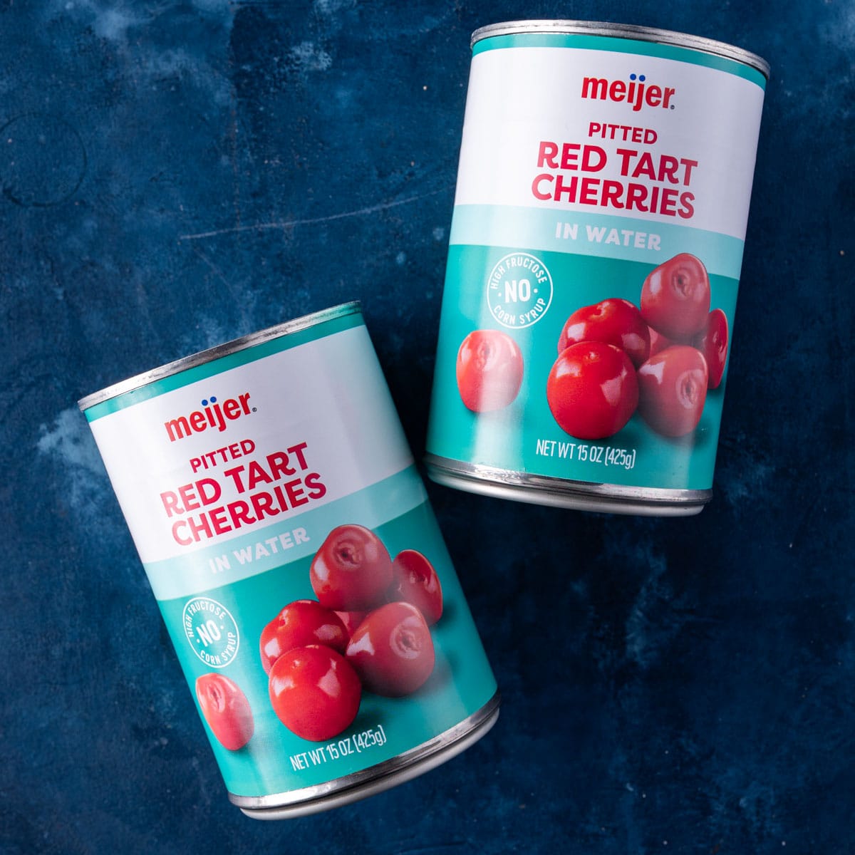 two cans of red tart cherries on a table