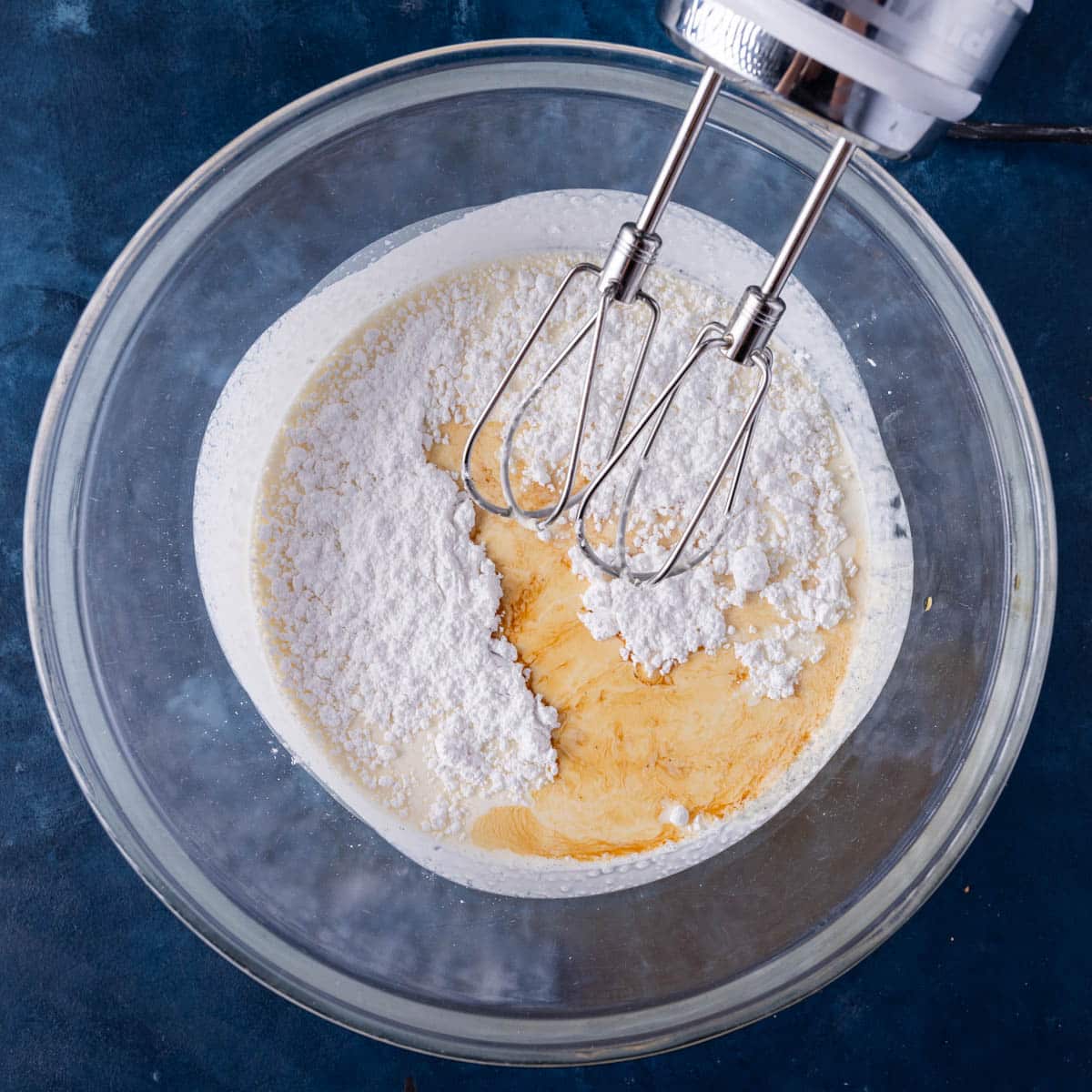 ingredients for whipped cream in a bowl with a mixer