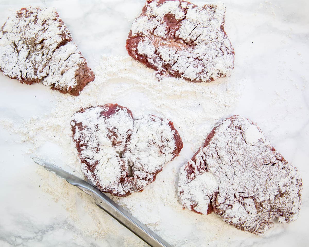 floured cube steaks on a table