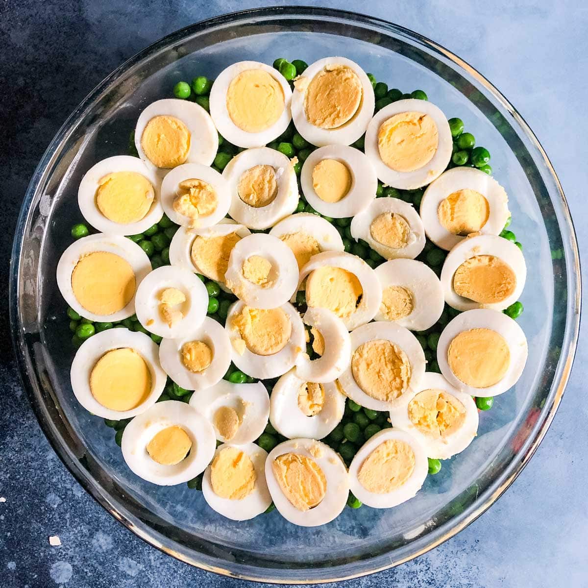 sliced hard boiled eggs in a seven layer salad