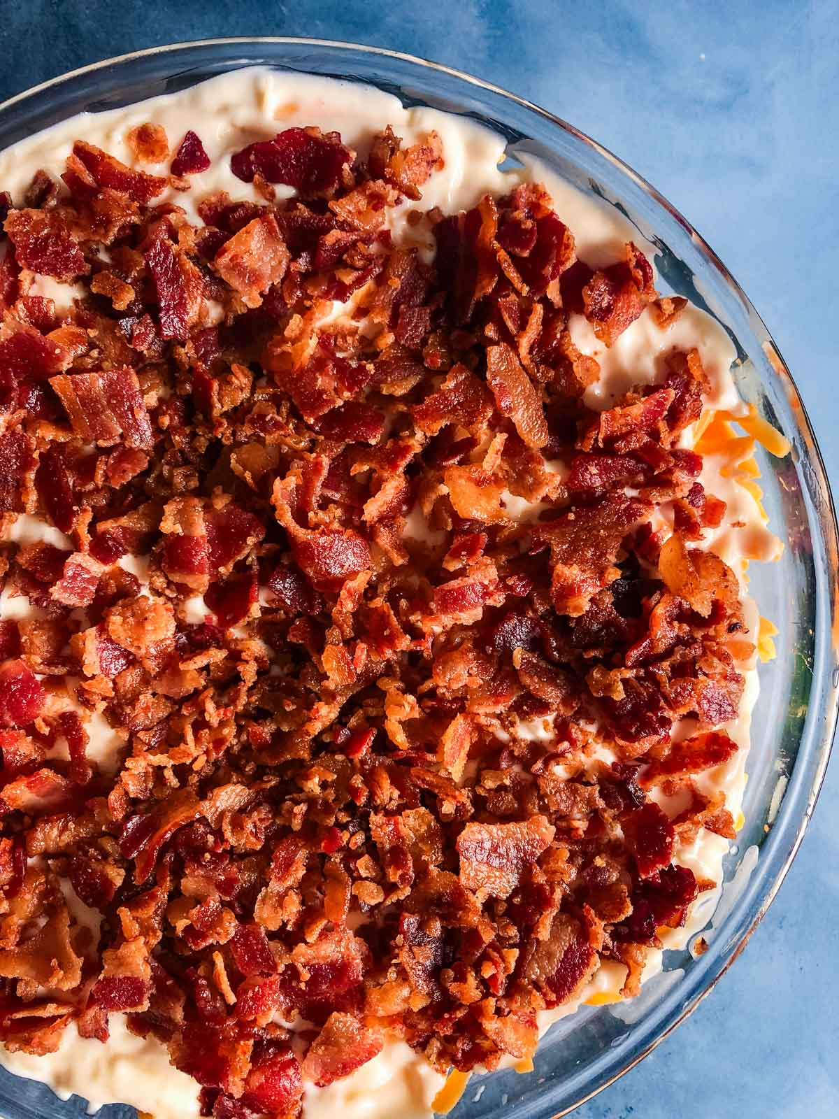 overhead view of a layered salad with maple bacon on top