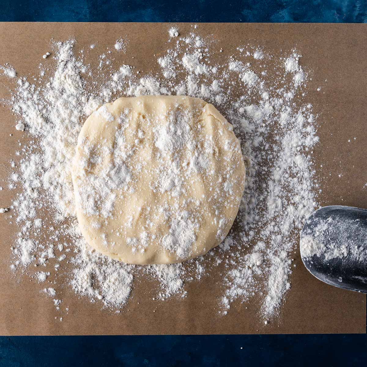 cookie dough on a piece of parchment paper with flour on top