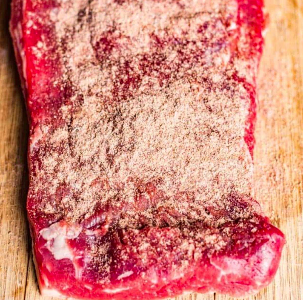 seasoned flank steak on a cutting board