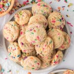 a pile of rainbow chip sprinkles cookies on a plate