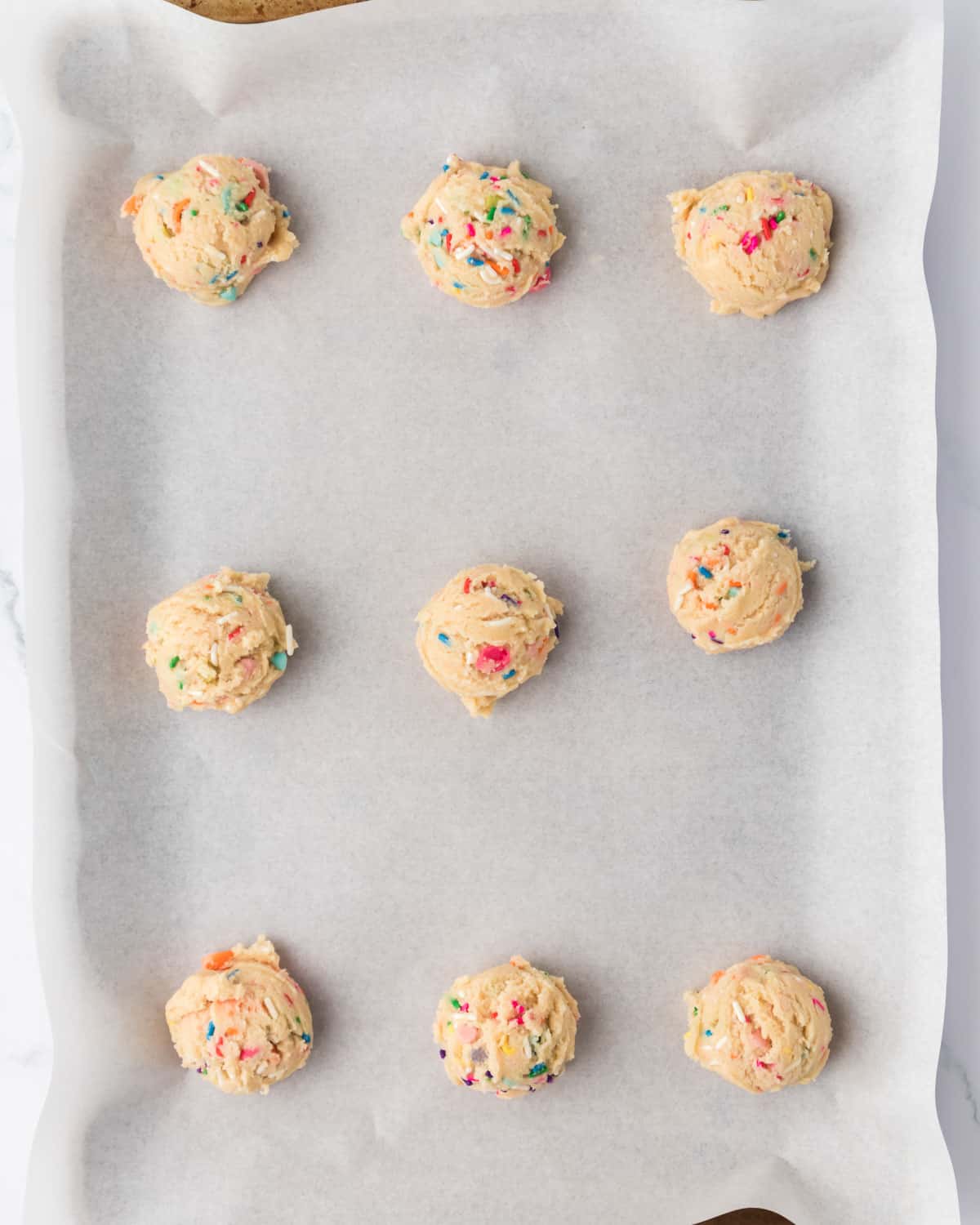 unbaked sprinkle cookies on a baking sheet