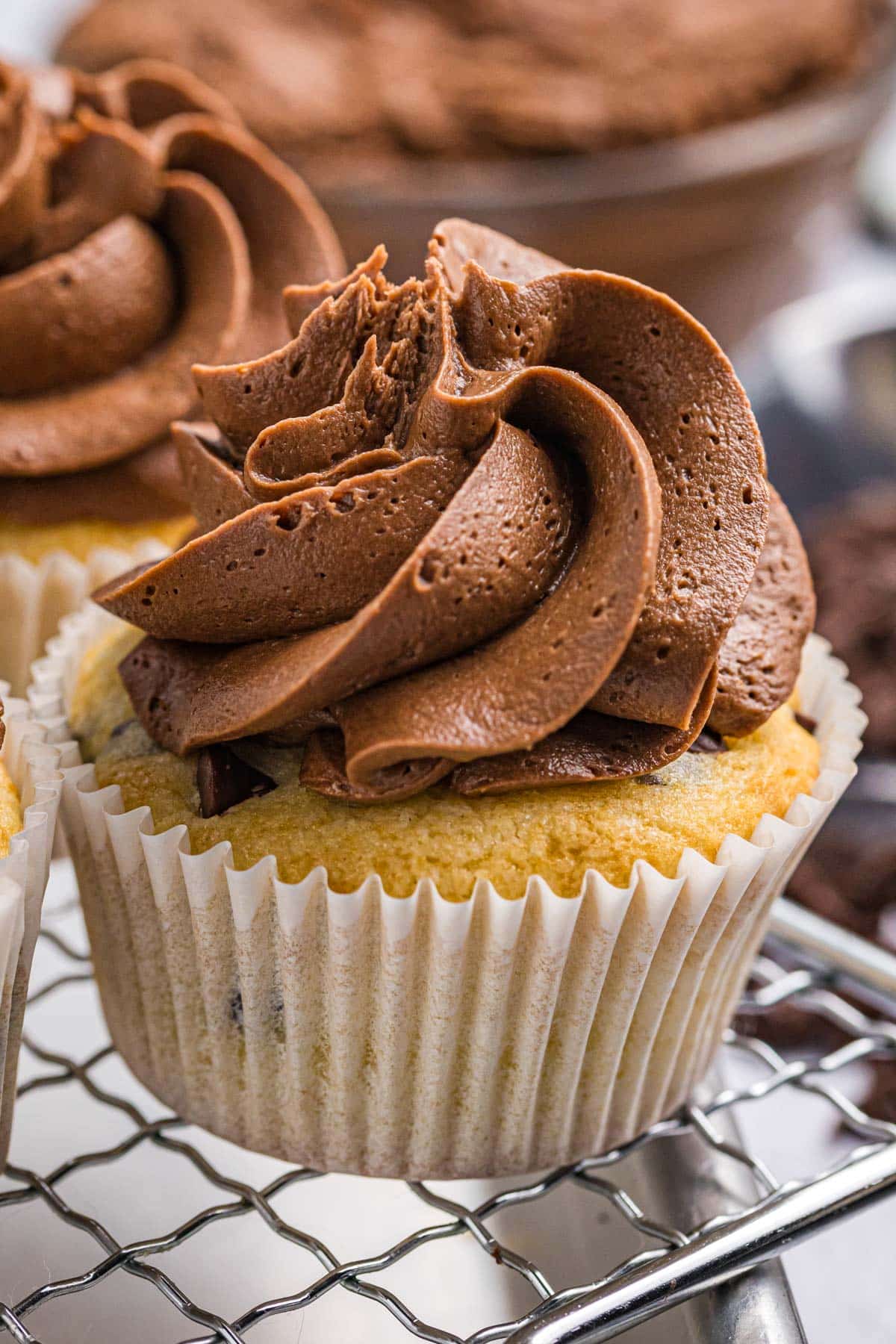 a frosted cupcake on a wire rack