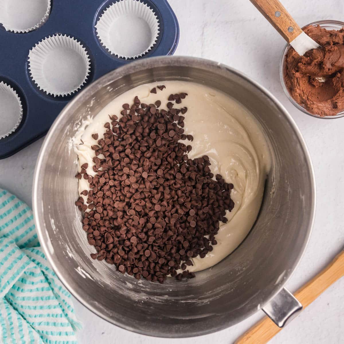 mini chocolate chips over white cake batter in a metal bowl