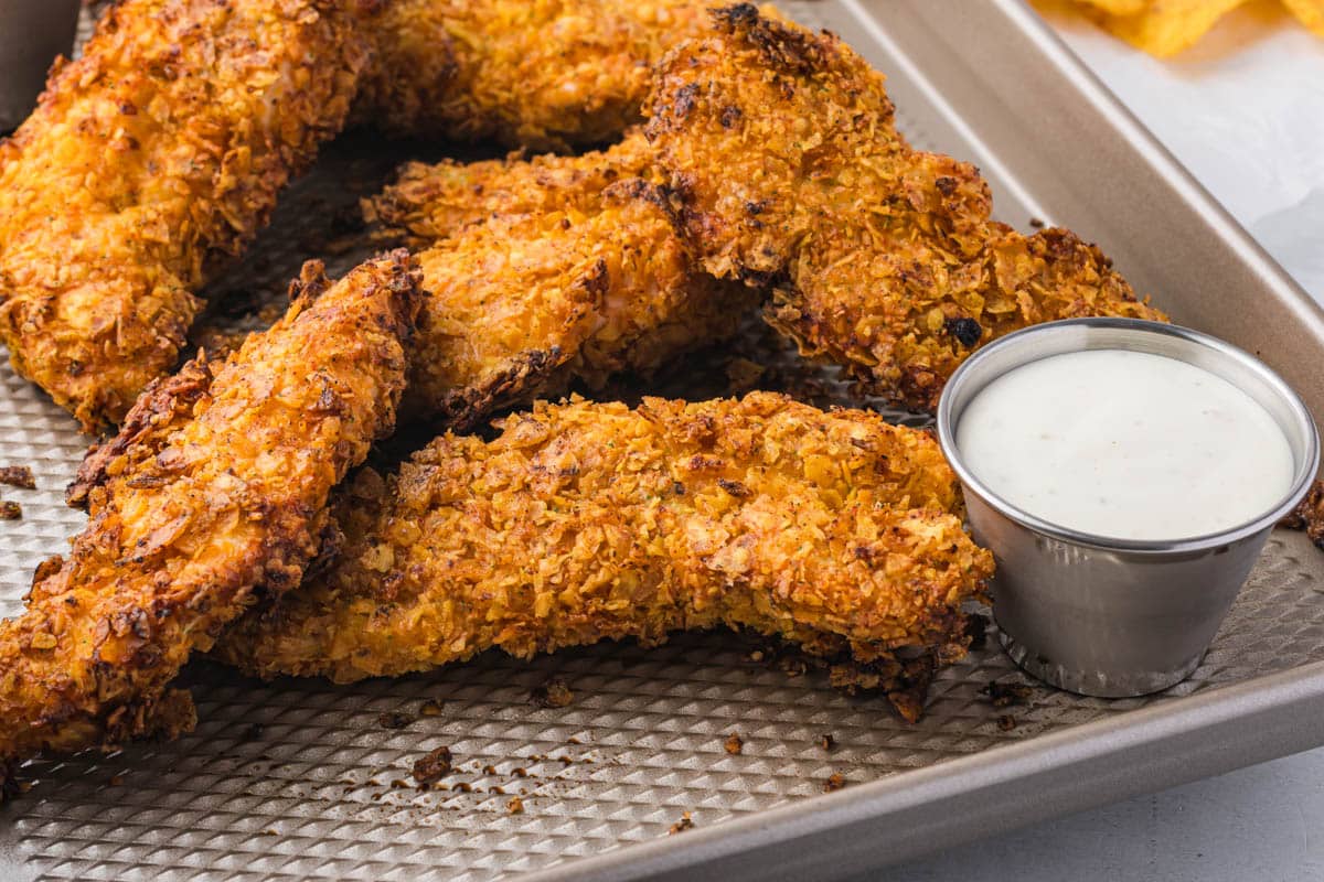 doritos chicken tenders with ranch dressing on a baking sheet