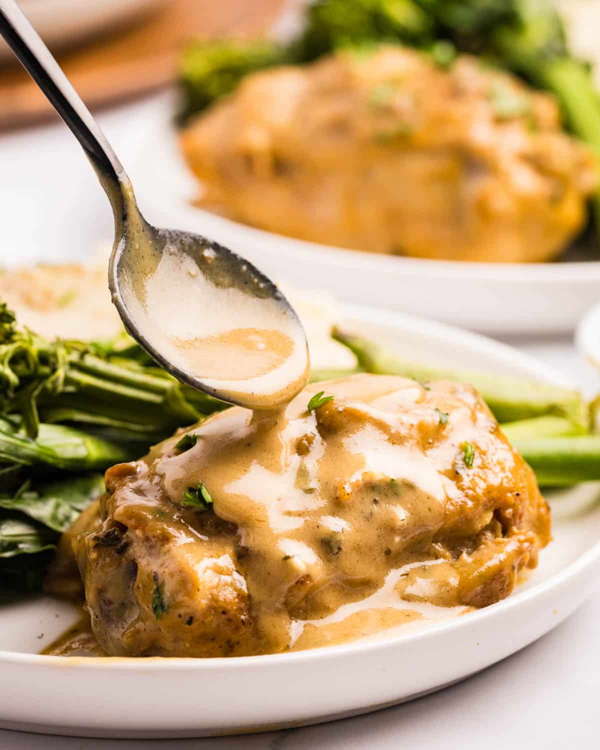 spooning honey mustard sauce over chicken