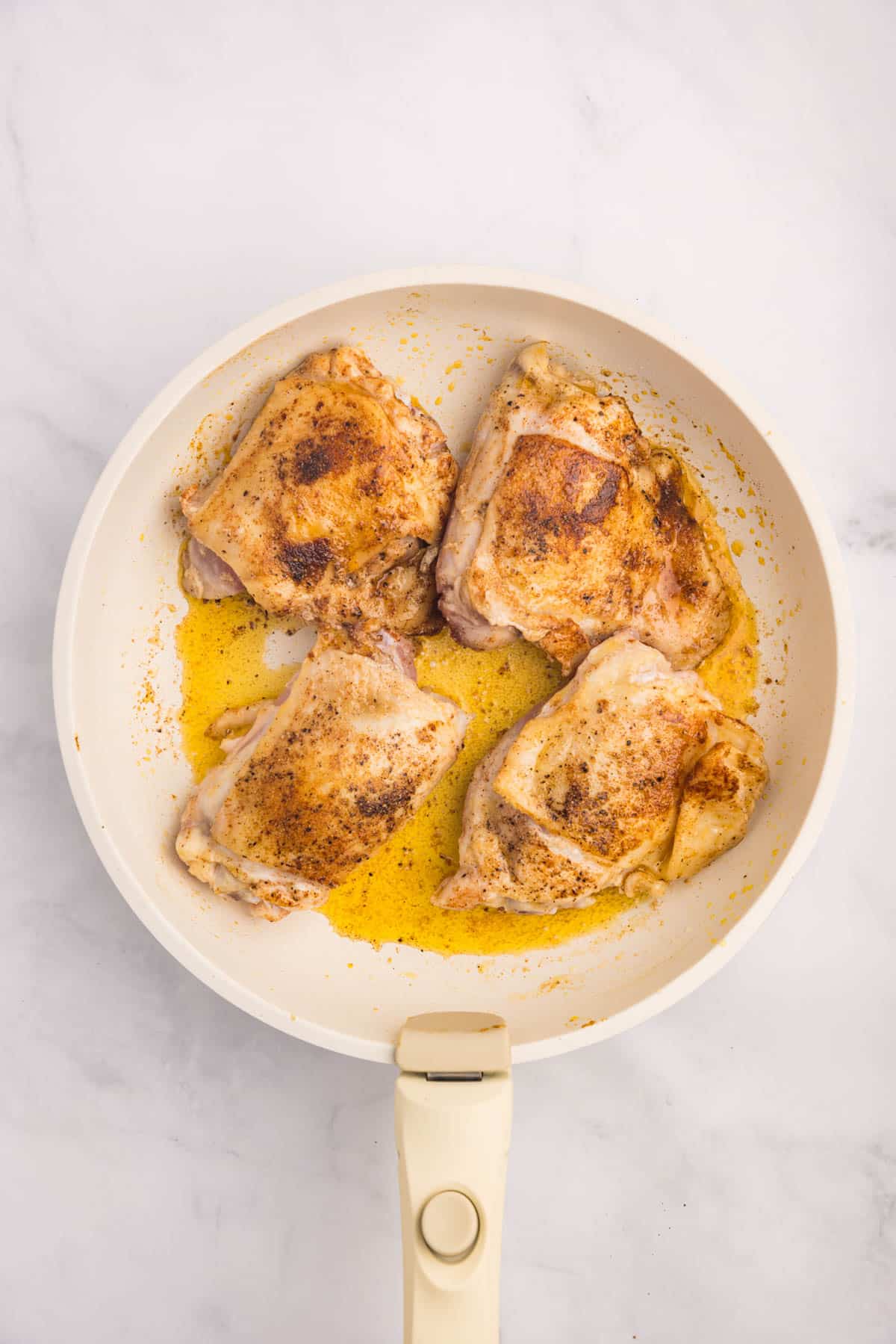 browned chicken thighs in a skillet