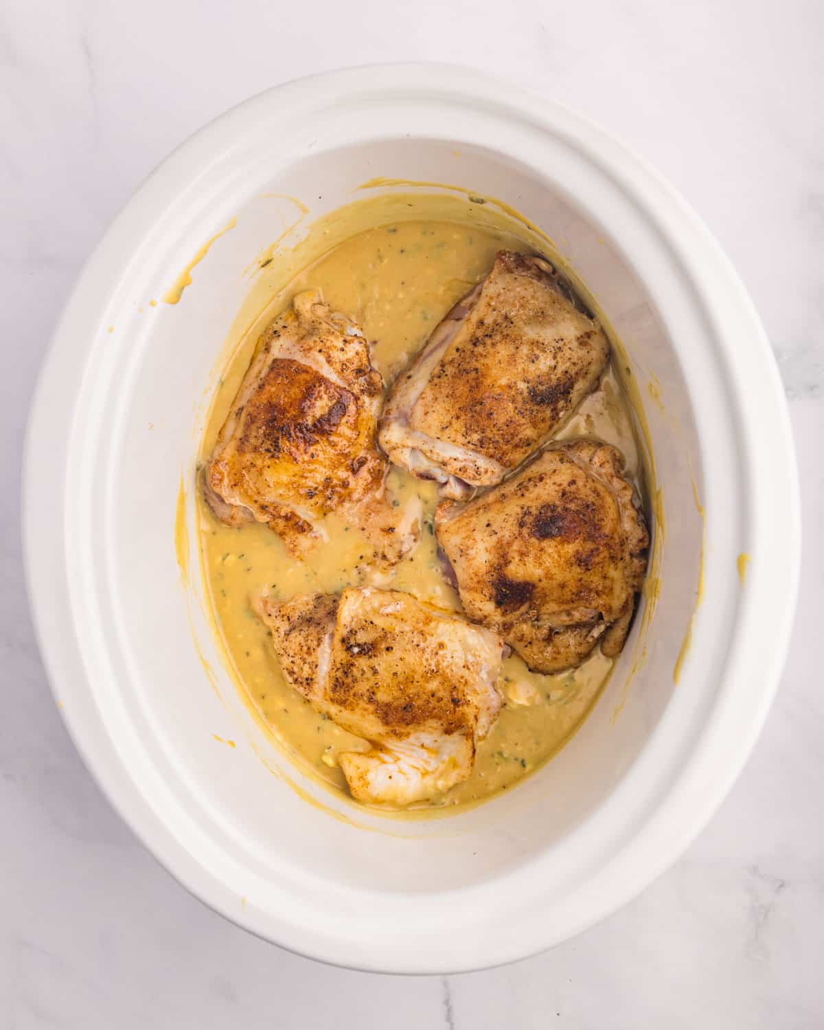 chicken over honey mustard sauce in a slow cooker