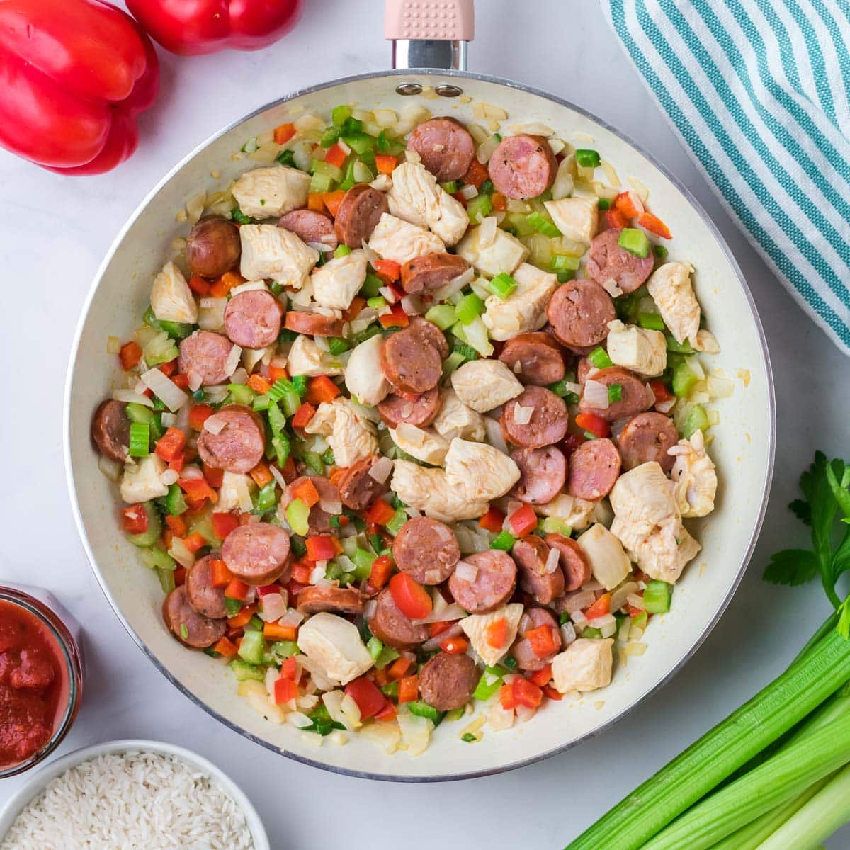 satueed sausage, chicken and veggies in a pan