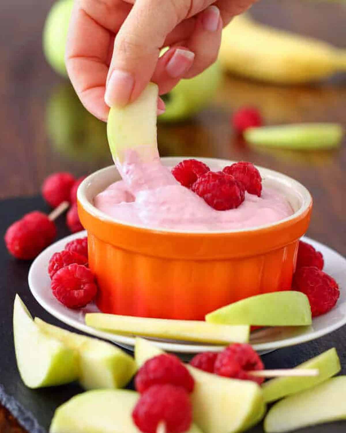 dipping in apple in raspberry fruit dip