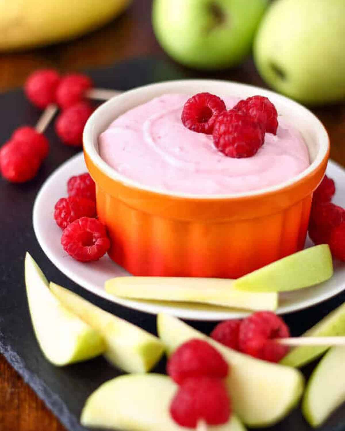 a small bowl of raspberry mascarpone dip with fresh raspberries