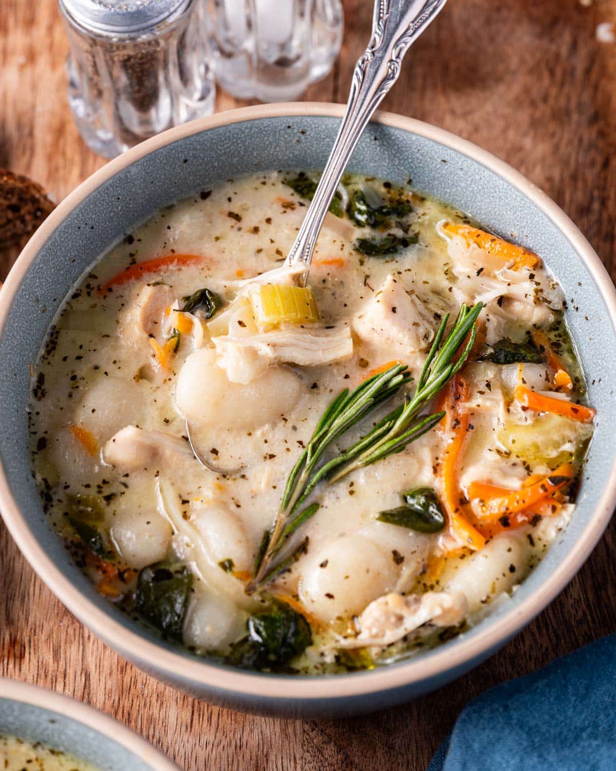 a bowl of chicken gnocchi soup with a spoon