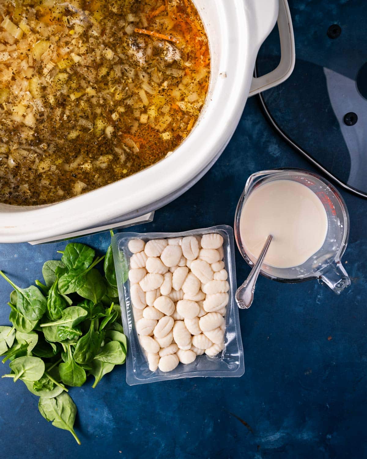 a crockpot with chicken gnocchi soup ingredients by it