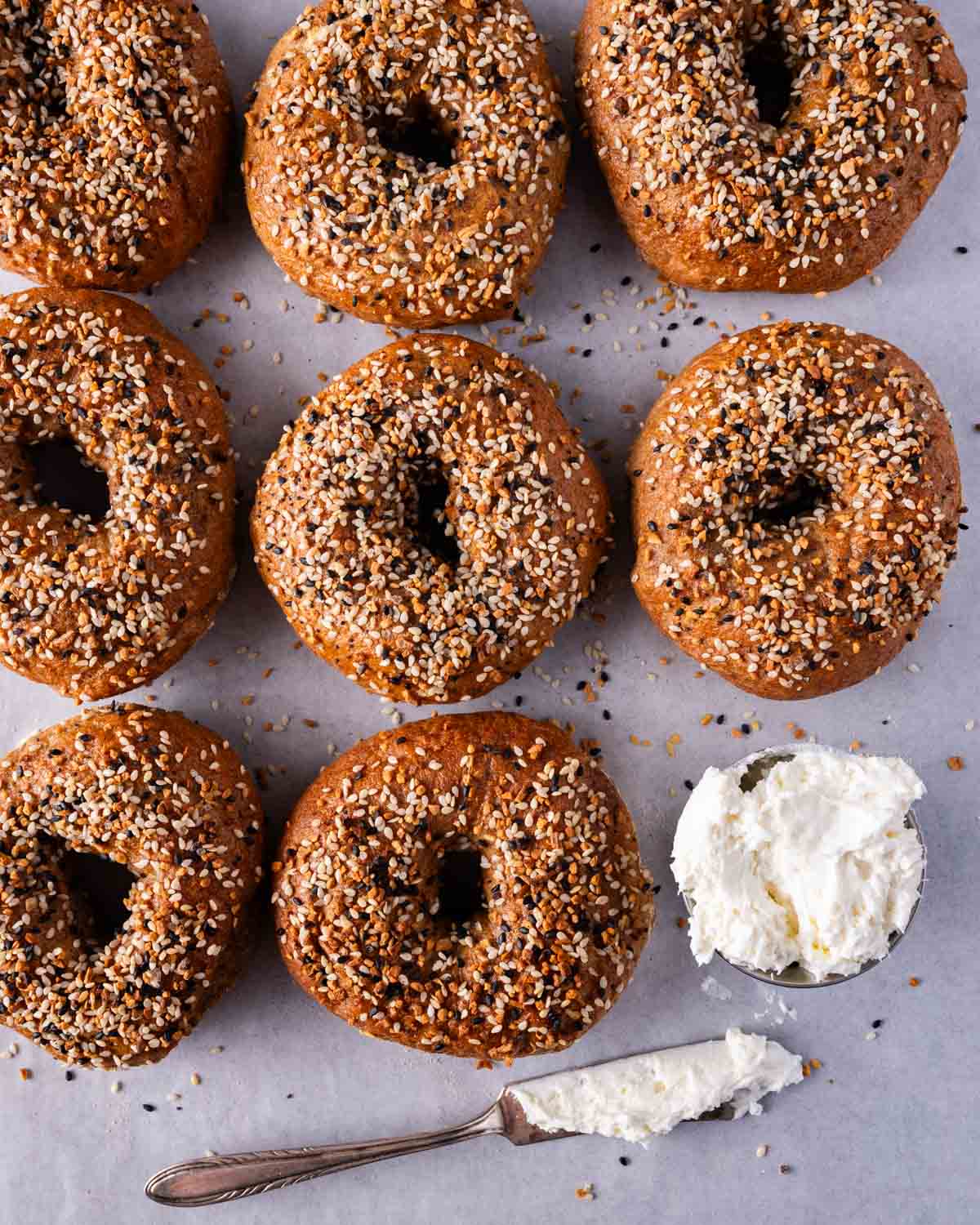 whole wheat bagels on a table with cream cheese