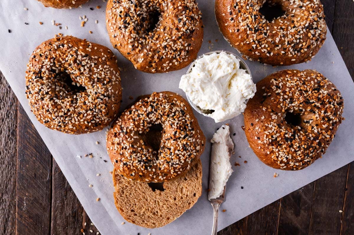 whole wheat bagels on a table with cream cheese