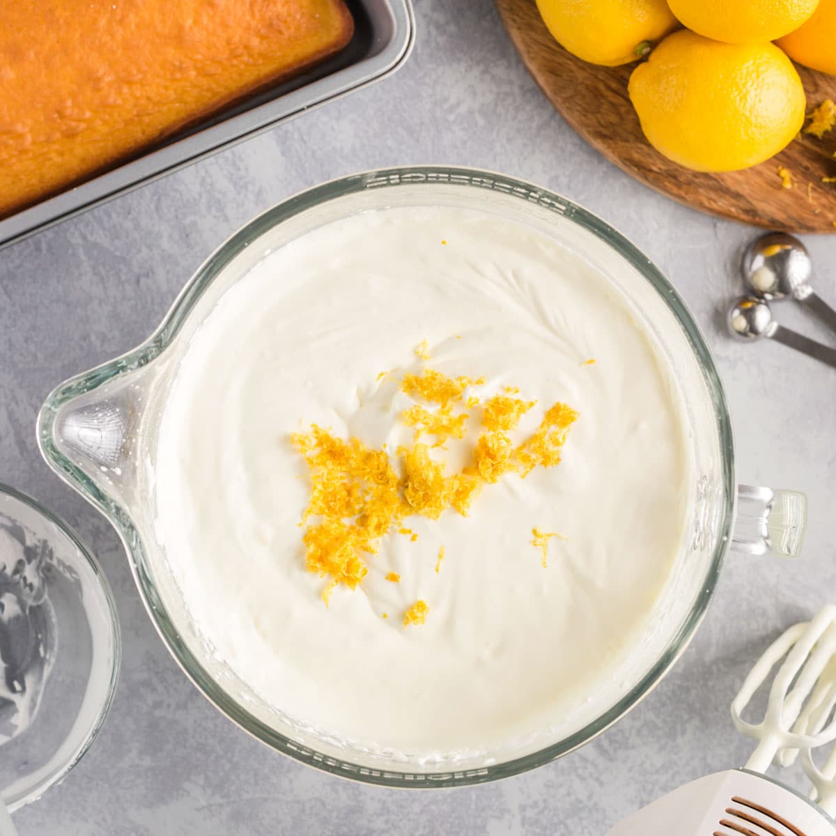 lemon zest over whipped topping in a glass bowl