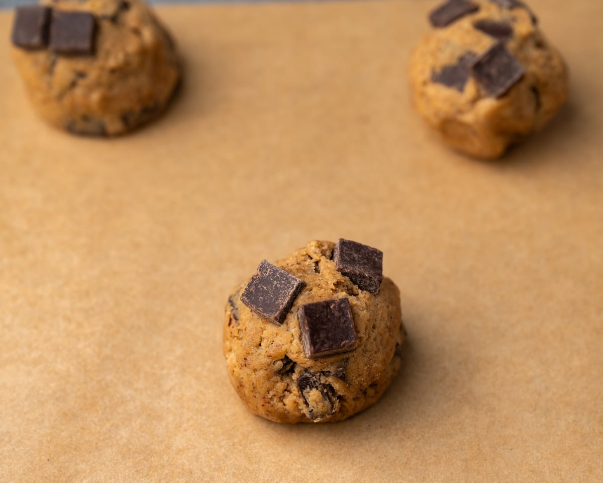 cookie dough ball with chocolate chunks on a baking mat