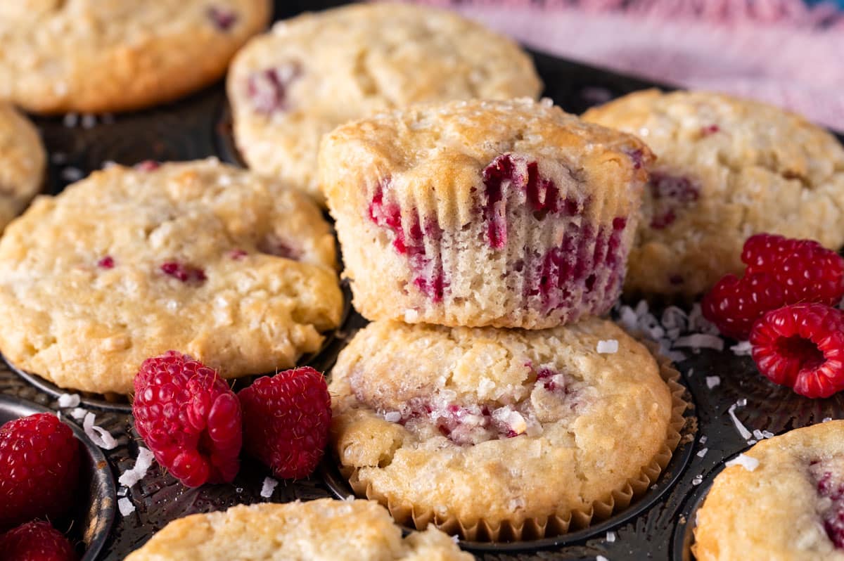 a raspberry coconut muffin sitting on top of muffin pan