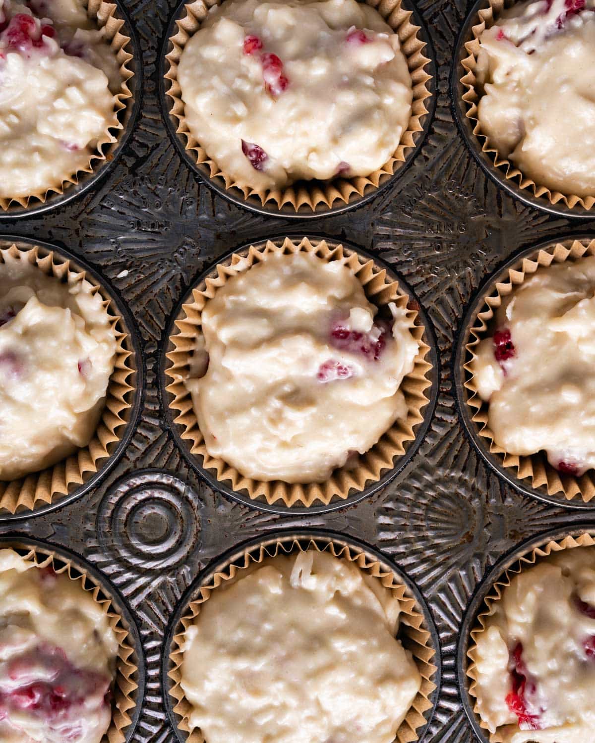 unbaked raspberry coconut muffins in a pan