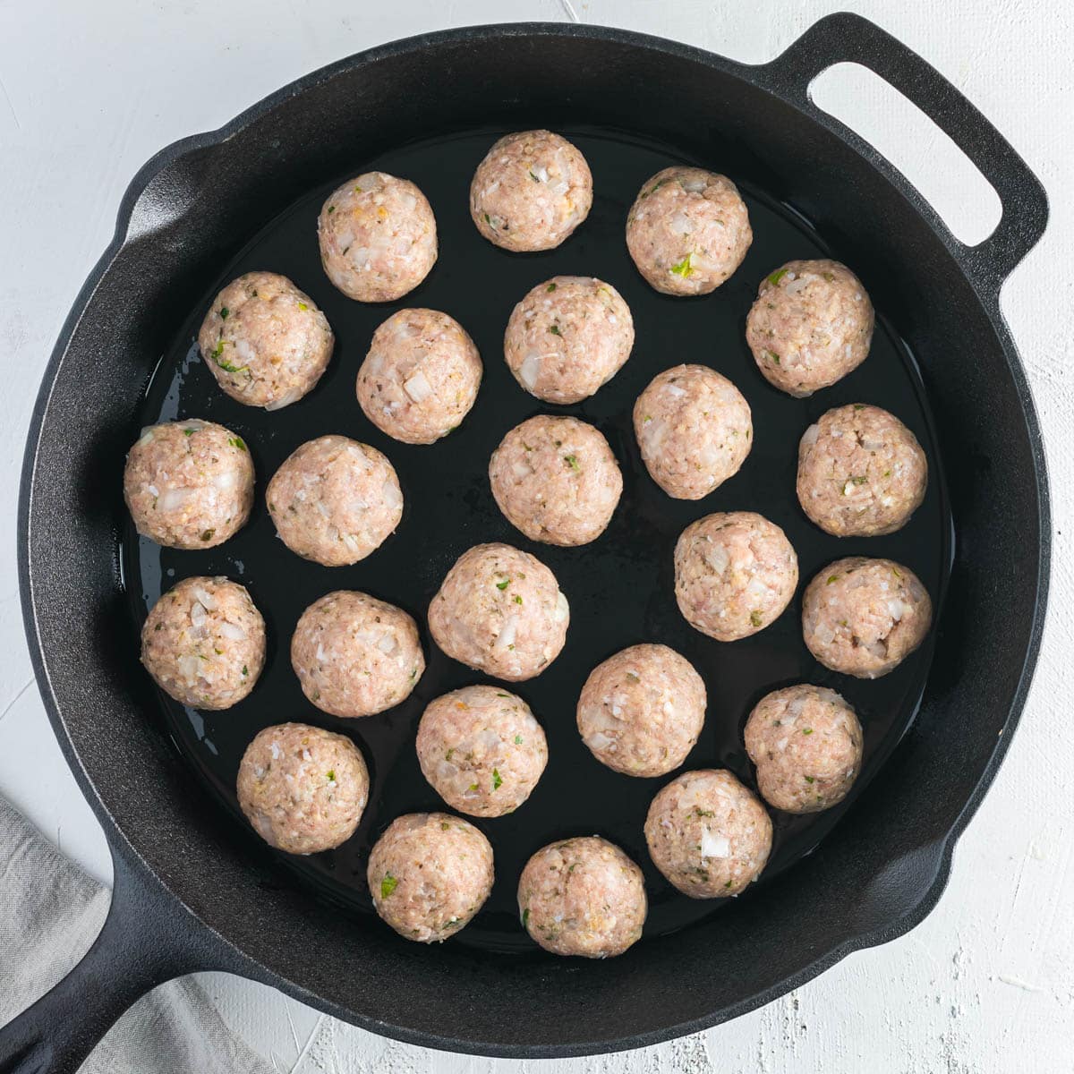 unbaked turkey meatballs in a cast iron skillet