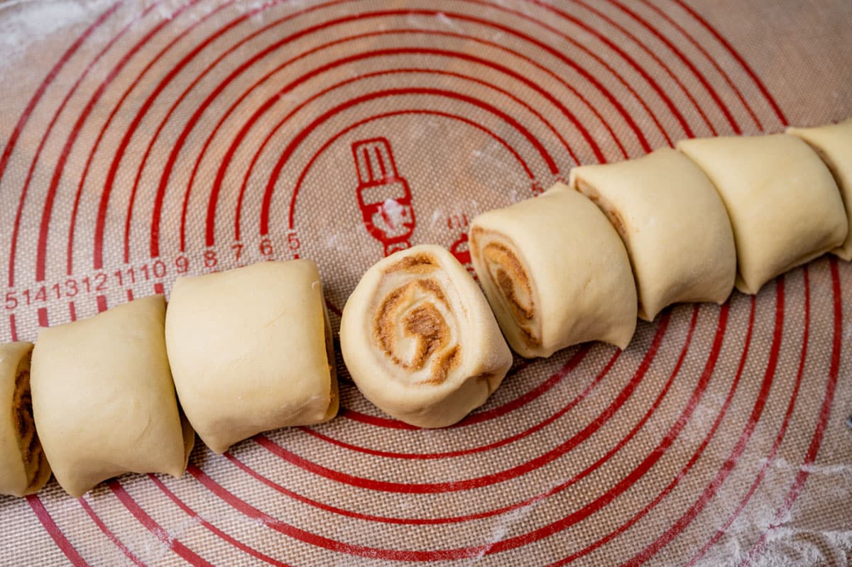 sliced cinnamon roll dough on a pastry mat